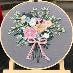 a bouquet of flowers on a gray background with pink and white roses in the center