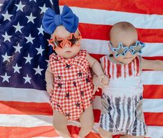 two dolls are laying next to each other on an american flag background, one is wearing sun glasses and the other has sunglasses