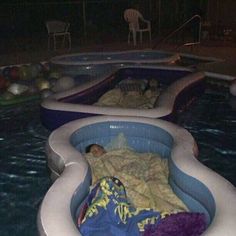 an inflatable pool with two people sleeping inside