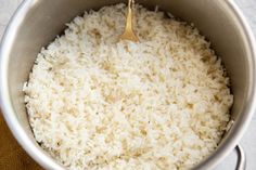 rice is being cooked in a pot with a wooden spoon