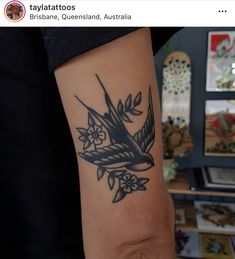 a black and white bird tattoo on the arm