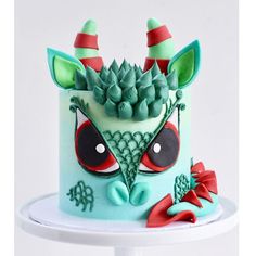 a cake decorated to look like an alien with green and red decorations on it's face