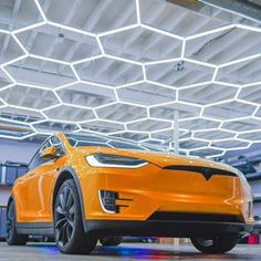 an orange electric car parked in a garage