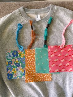 four pieces of fabric are laid out on the floor to be used as purses