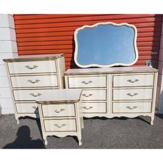 two white dressers and a mirror sitting next to each other