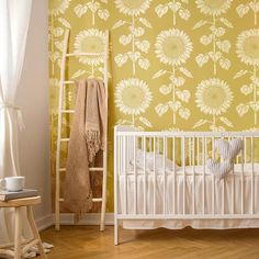 a white crib in front of a yellow wallpaper