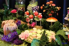 a table topped with lots of different types of flowers and cake pops on top of it