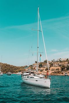 a white sailboat floating on top of a body of water