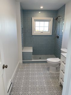 a white toilet sitting in a bathroom next to a window