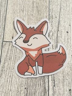 a sticker with an image of a fox sitting on top of a wooden floor