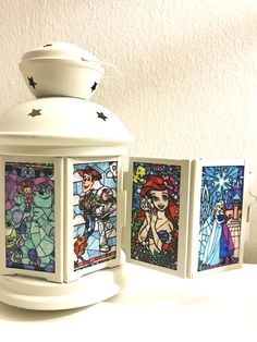 three small stained glass lanterns sitting on top of a white table next to each other