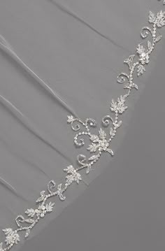 a wedding veil with white flowers on it