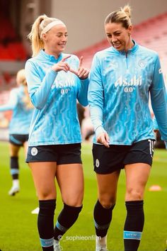 two female soccer players are walking on the field