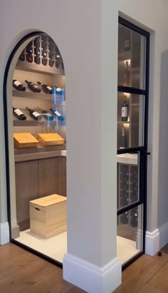 a wine cellar with several bottles in the wall and shelves on either side of it