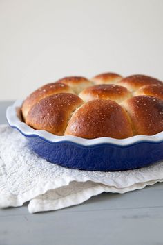 a blue dish filled with bread on top of a white cloth