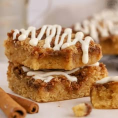 cinnamon roll bars with icing on top and cinnamon sticks around the edges, ready to be eaten