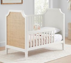 a white crib with a stuffed animal in it