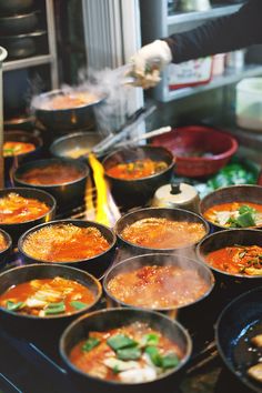 many bowls of food are being prepared on the stove