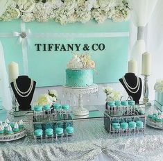 a table topped with cakes and cupcakes covered in blue frosted icing