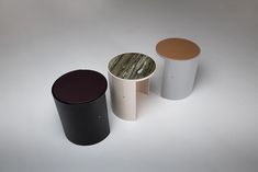 three different colored cups sitting next to each other on top of a white countertop