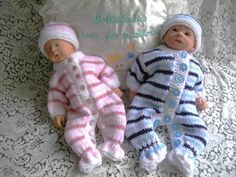 two baby dolls laying next to each other on a bed