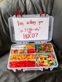 a plastic container filled with lots of different colored gummy bears and an i'm okay sign