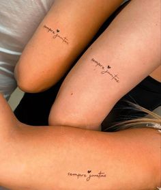 two girls with matching tattoos on their arms, one has the word love and the other says