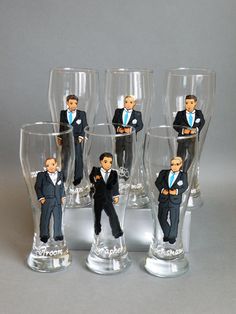 five plastic figurines of men in suits and ties are lined up next to each other