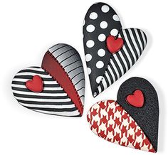 three heart shaped magnets with hearts on them, one is black and the other is red