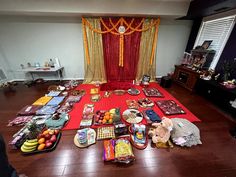 a room filled with lots of food on top of a wooden floor next to a red rug