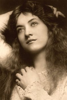 an old black and white photo of a woman with her hair blowing in the wind