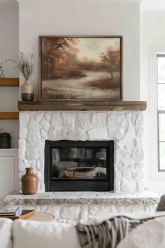 a living room with a fire place and painting on the wall above it's mantle