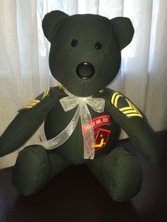 a green teddy bear sitting on top of a table