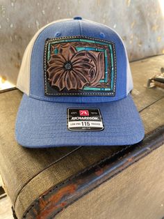 Daisy Patch Hat with Turquoise Southwestern Border. Hand tooled daisy and turquoise southwestern border. The turquoise border is painted with four different tones of turquoise. Sewn onto the popular Richardson 115, the perfect trucker hat. Blue Artisan Hat With Flat Brim, Artisan Blue Hat With Flat Brim, Artisan Blue Flat Brim Hat, Blue Country Style Hat, Country Style Blue Hat, Blue Country Hat With Curved Brim, Blue Country Style Hat With Curved Brim, Country Style Blue Hat With Curved Brim, Flat Brim Blue Hats For Ranch