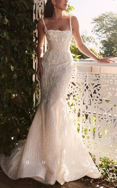 a woman in a wedding dress leaning against a wall with her hand on the shoulder