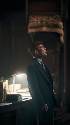 a man in a suit standing next to a desk