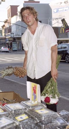 a man standing in front of a table filled with pineapples and other items