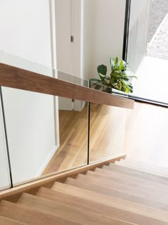 there is a glass and wood stair case on the floor in this house with white walls