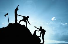 two people are climbing up the side of a mountain with their arms in the air