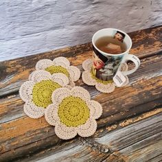 four crocheted coasters and a cup of tea on a wooden table top