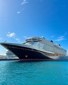 a large cruise ship in the water with other ships behind it on a sunny day