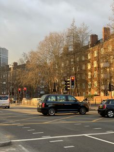 two cars are stopped at an intersection in the city