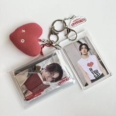 two key chains with pictures on them and a red heart