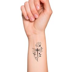 a woman's arm with a tattoo that has a dragonfly and flowers on it