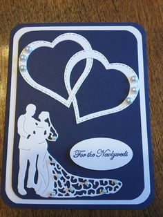 a wedding card with two hearts and a silhouette of a bride and groom on it