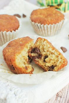 a muffin cut in half sitting on top of a white napkin next to some chocolate chips