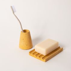 a soap dish and toothbrush holder sitting next to each other on a white surface