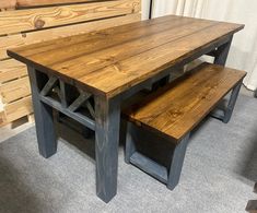 a wooden table with two benches next to it on carpeted floor in front of wall