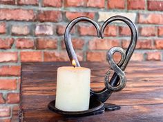 a candle is placed in the shape of a heart on top of a wooden table