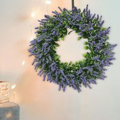 a wreath is hanging on the wall with lights around it